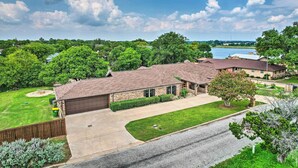 A residential area with a house featuring a brick exterior, a driveway, and a well-maintained lawn. - Luxury Granbury Home w/ Private Boat Dock! (Granbury)
