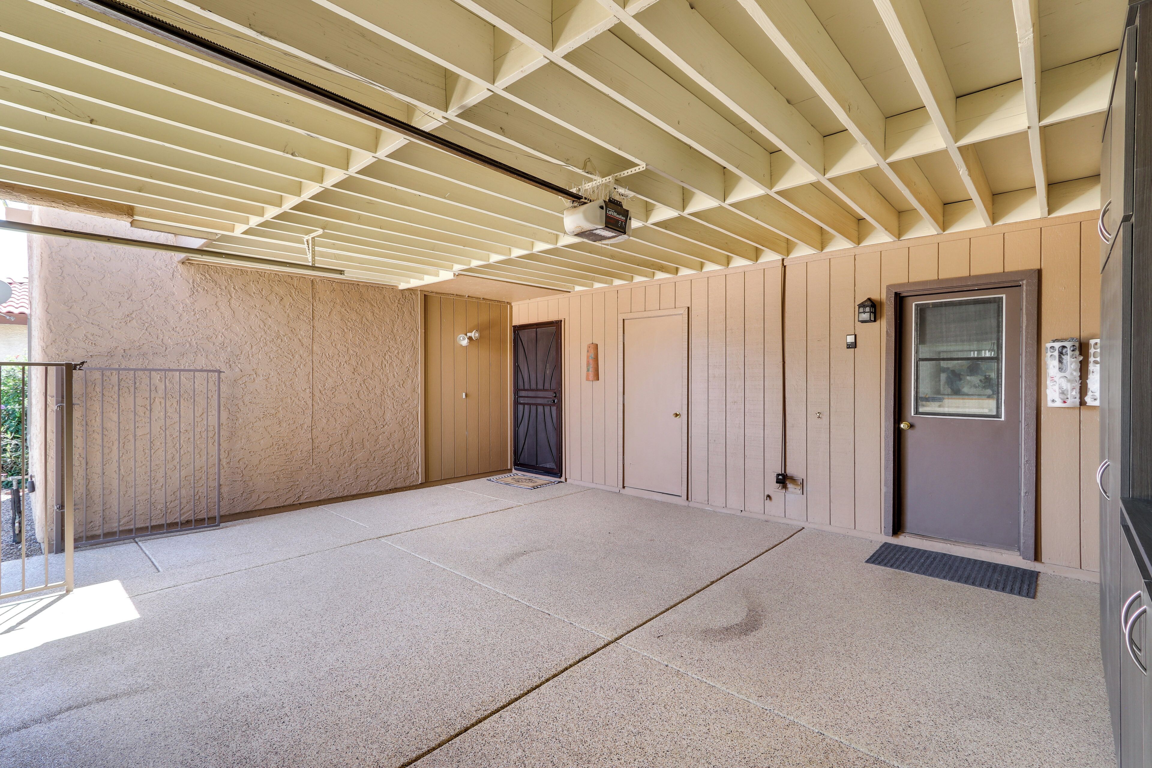 A covered outdoor area with a concrete floor, a door, and a window.