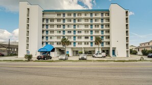 Un hôtel à plusieurs étages, doté d’une façade sobre, de balcons et d’un espace de stationnement situé à l’avant.