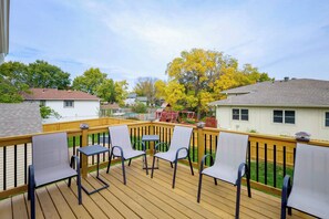 A wooden deck with outdoor furniture and a view of neighboring houses. - Pet-friendly Omaha Vacation Rental w/ Deck! (Omaha)