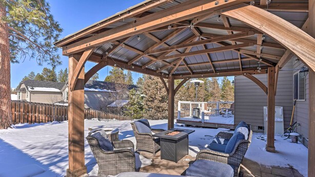 A covered patio area with wicker furniture and a fire pit. - Family-friendly Oregon Vacation Home w/ Yard (Bend)