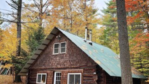 A rustic log cabin with a metal roof, two windows, and a chimney. - Cozy Elizabethtown Cabin w/ Fire Pit! (Elizabethtown)