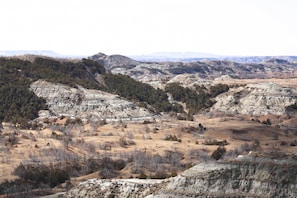 A panoramic view of a mountainous landscape with rocky terrain and sparse vegetation. - Ranch Suite of Dakota Place Lodge 'in' Medora! (Medora)