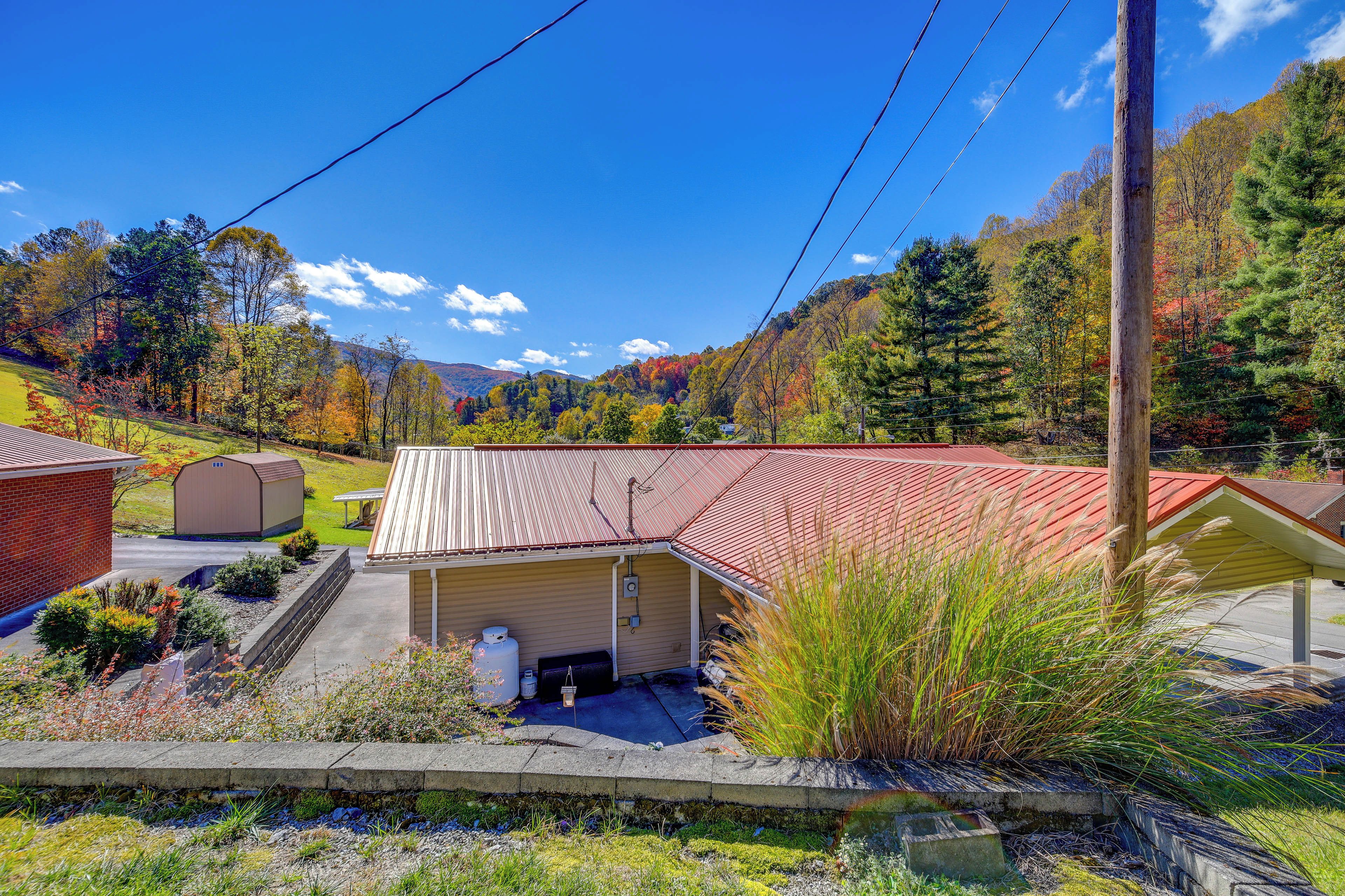 A building with a red roof, a covered outdoor area, and a view of a mountainous landscape.
