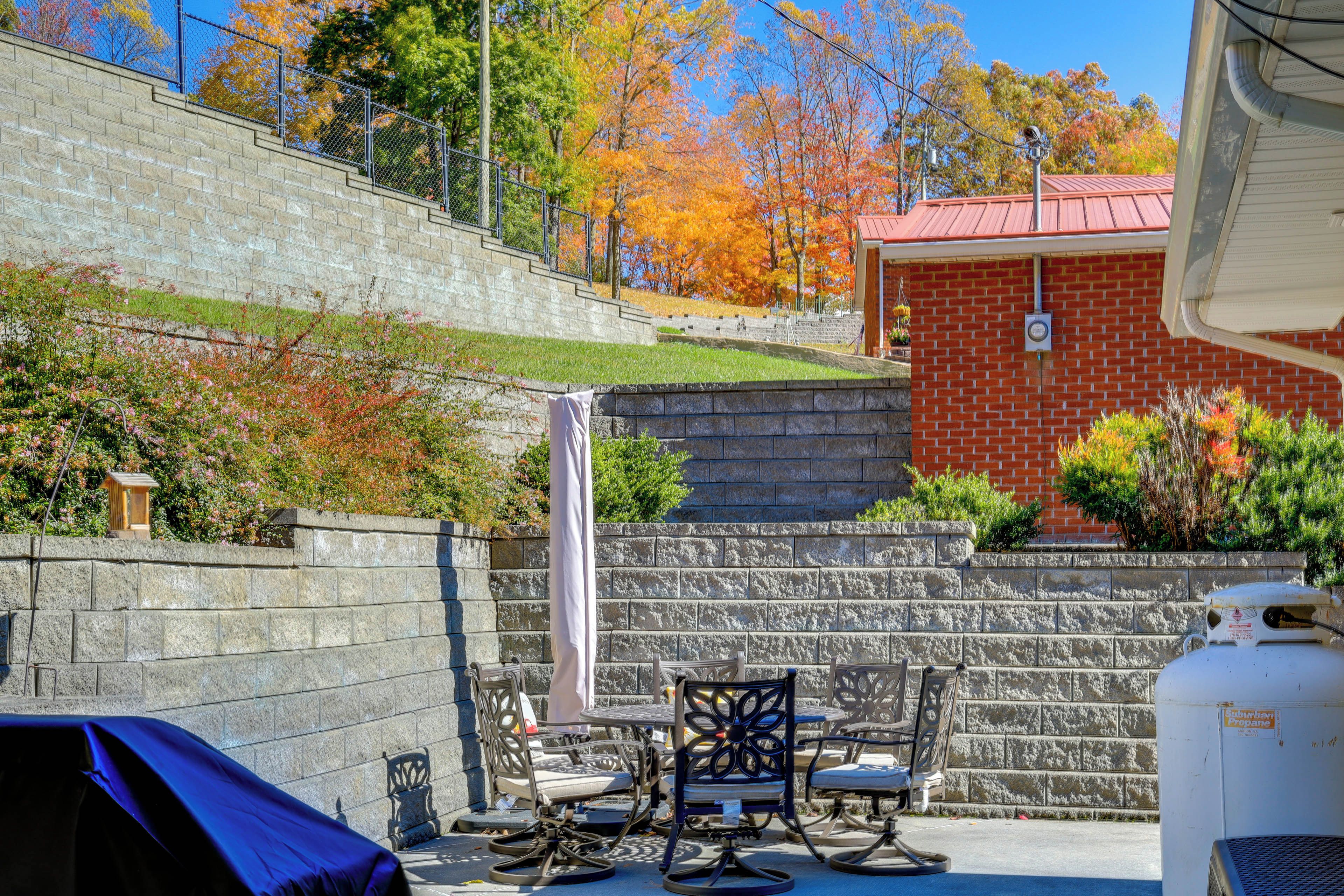 A patio area with a brick wall, outdoor seating, and a gas tank.