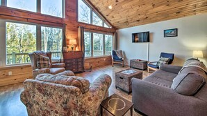 A spacious living room with large windows, wooden ceiling, and comfortable seating. - Stunning Monson Getaway on the Water! (Monson)