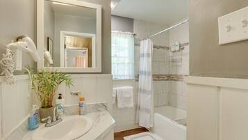 Une salle de bain avec un lavabo, un miroir et un espace douche.