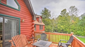 A wooden deck with Adirondack chairs and a table, overlooking a forested area. - Grand Windham Retreat w/ Fire Pit & Game Room (Windham)