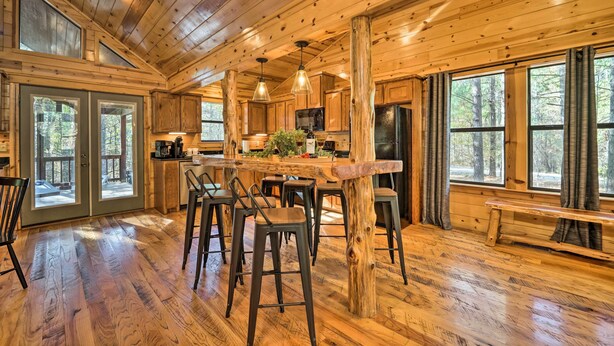 A spacious wooden cabin with a large dining area, bar, and kitchen.