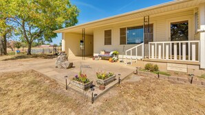 A single-story house with a porch, a stone planter with flowers, and a 'COTEAM' sign. - Charming Subiaco Getaway Near Arkansas River! (Subiaco)
