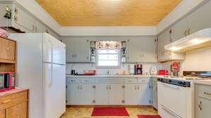 A kitchen with a refrigerator, stove, microwave, and various kitchen appliances. - Charming Subiaco Getaway Near Arkansas River! (Subiaco)