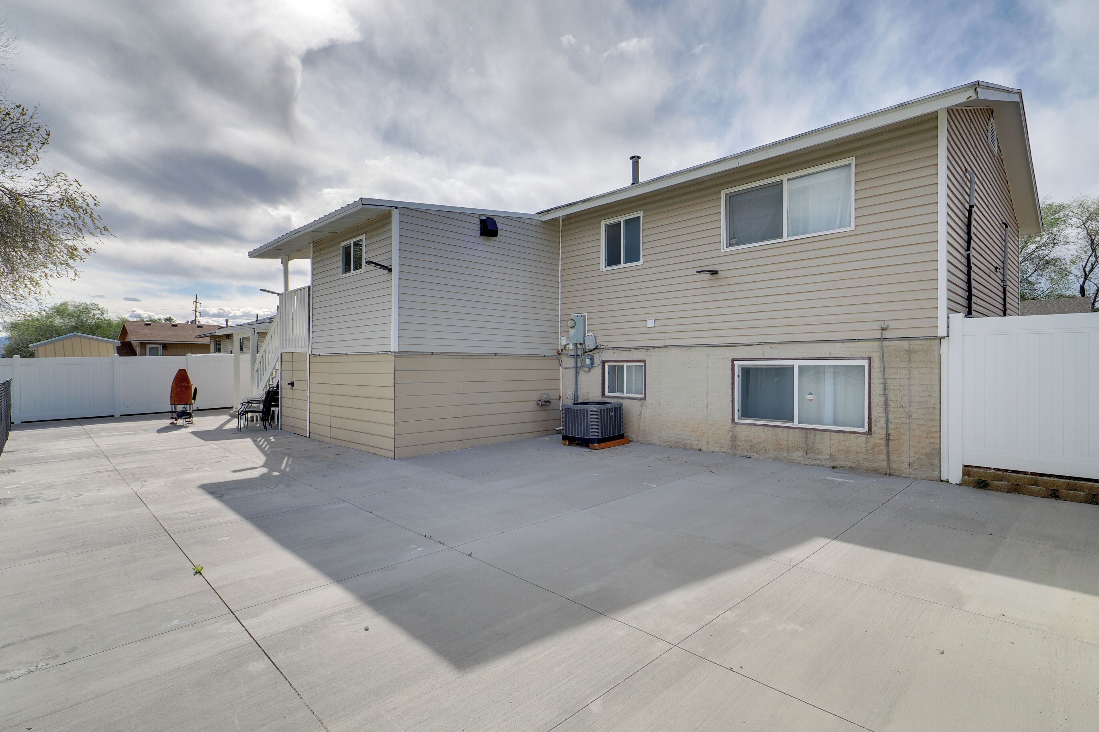 A two-story house with a covered patio, a garage, and a utility area.
