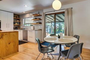 A modern kitchen with white cabinets, a wooden countertop, and a dining area with a round table and chairs. - < 3 Mi to Pearl St: Home w/ Large Yard in Boulder (Boulder)