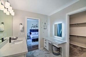 Ein modernes Badezimmer mit Waschbecken, Spiegel und Handtuchhalter.