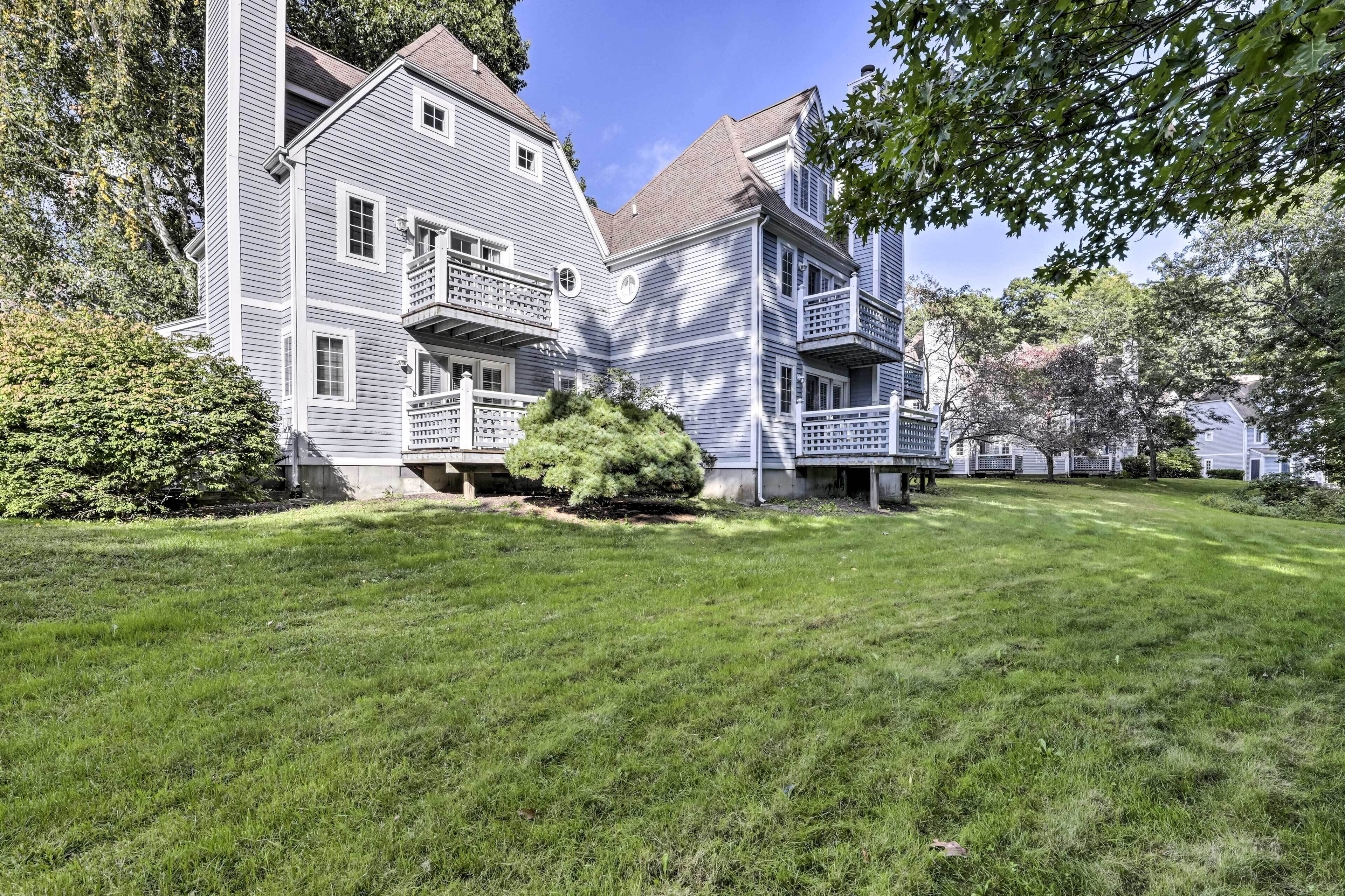 A large, two-story house with a well-maintained lawn and a small tree in front.