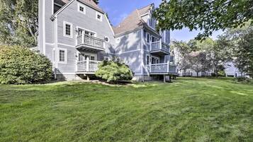 A large, two-story house with a well-maintained lawn and a small tree in front.
