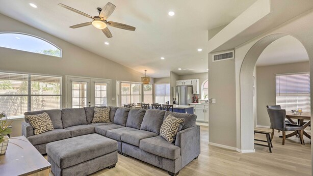 A spacious living room with a large sectional sofa, a ceiling fan, and a dining area with a table and chairs. - Private Pool & Fenced Yard: Phoenix Home (Phoenix)