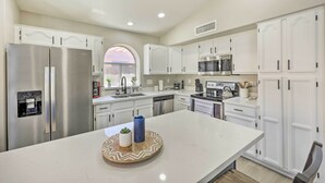 A modern kitchen with white cabinetry, stainless steel appliances, and a central island. - Private Pool & Fenced Yard: Phoenix Home (Phoenix)