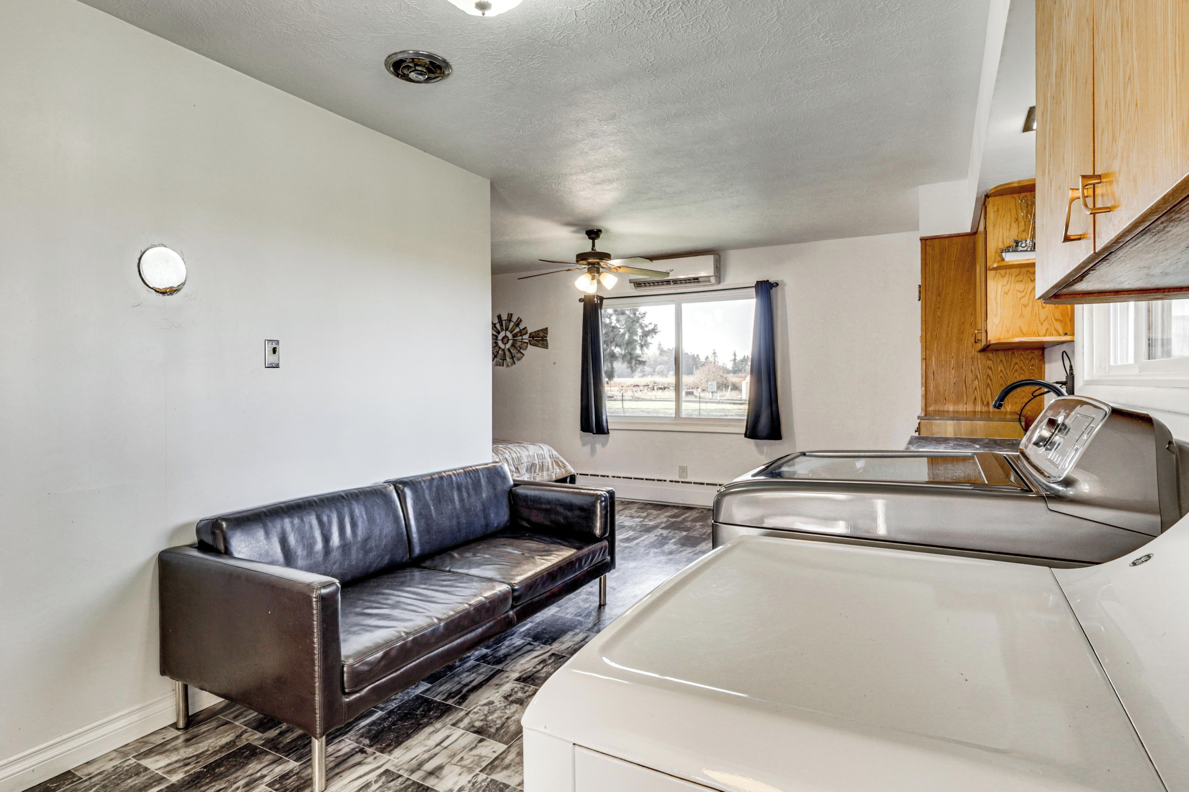 A compact living space with a kitchenette, a sofa, and a ceiling fan.