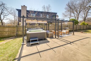 A backyard with a hot tub, patio furniture, and a pergola. - Lovely Kalamazoo River Home w/ Dock & Hot Tub (Saugatuck)