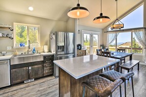 A modern kitchen with a large island, stainless steel appliances, and a dining area with a view. - Mtn View Anchorage Escape ~ 15 Mi to Downtown (Anchorage)