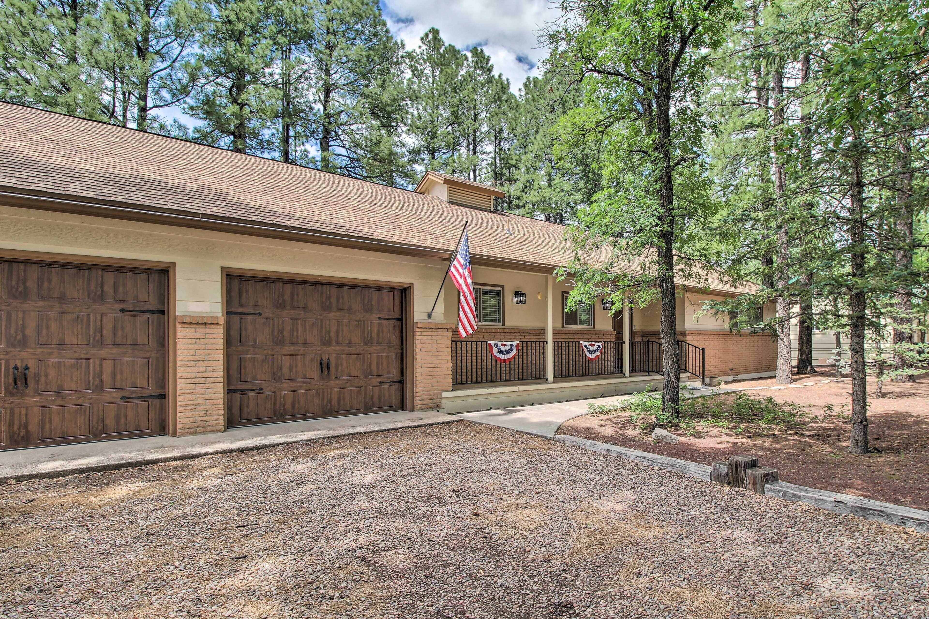 A two-story building with a covered porch and a gravel driveway.