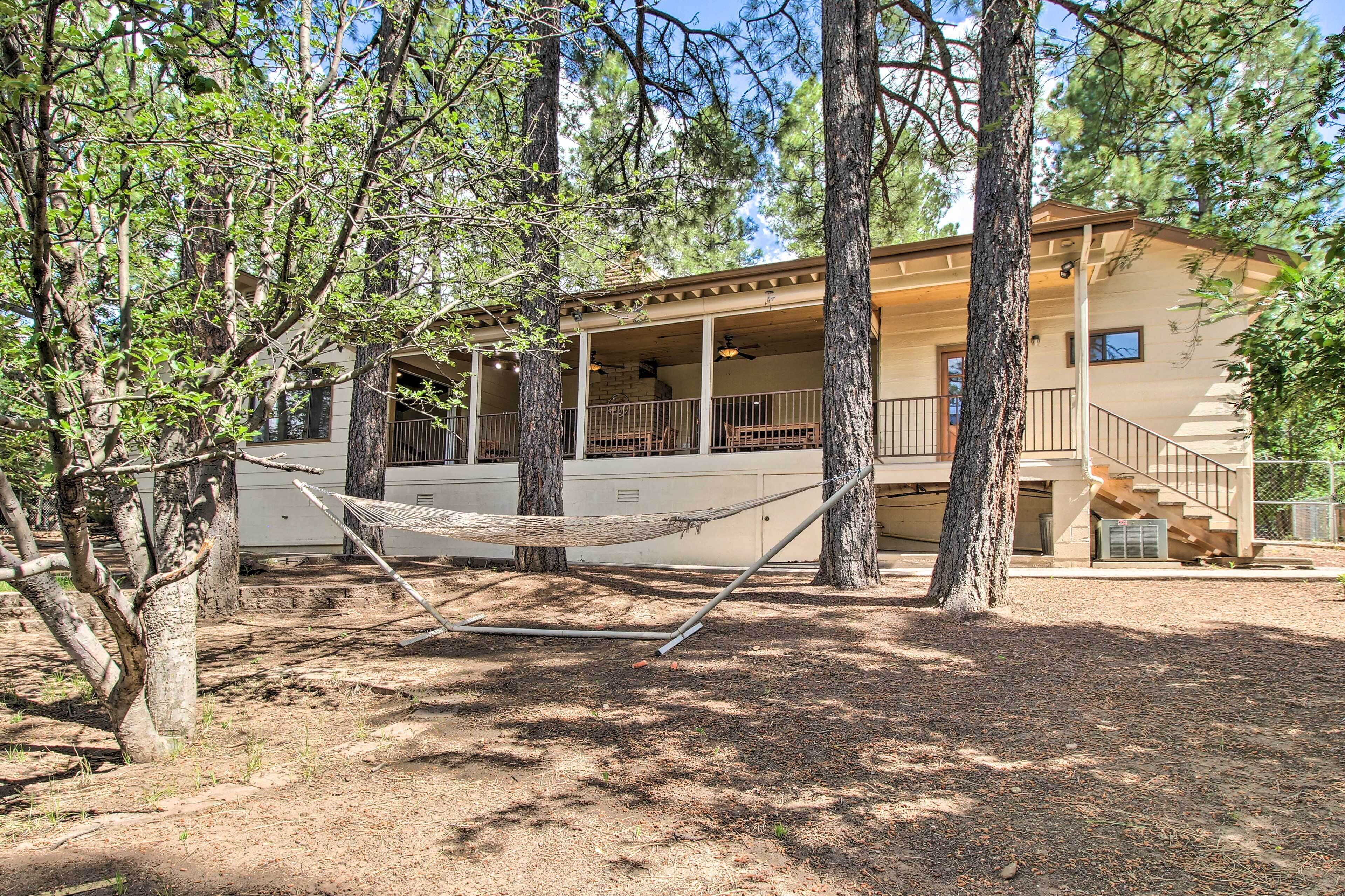 A two-story building with a covered porch, a hammock, and a staircase leading to the upper level.