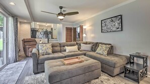 A modern living room with a sectional sofa, ottoman, and a ceiling fan. - Updated High Point Retreat w/ Pool & Backyard (High Point)