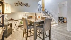A dining area with a marble table, leather chairs, and a decorative leaf wall piece. - Updated High Point Retreat w/ Pool & Backyard (High Point)