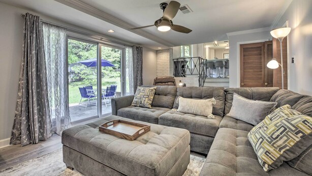 A living room with a grey sectional sofa, a wooden coffee table, and a ceiling fan. - Updated High Point Retreat w/ Pool & Backyard (High Point)