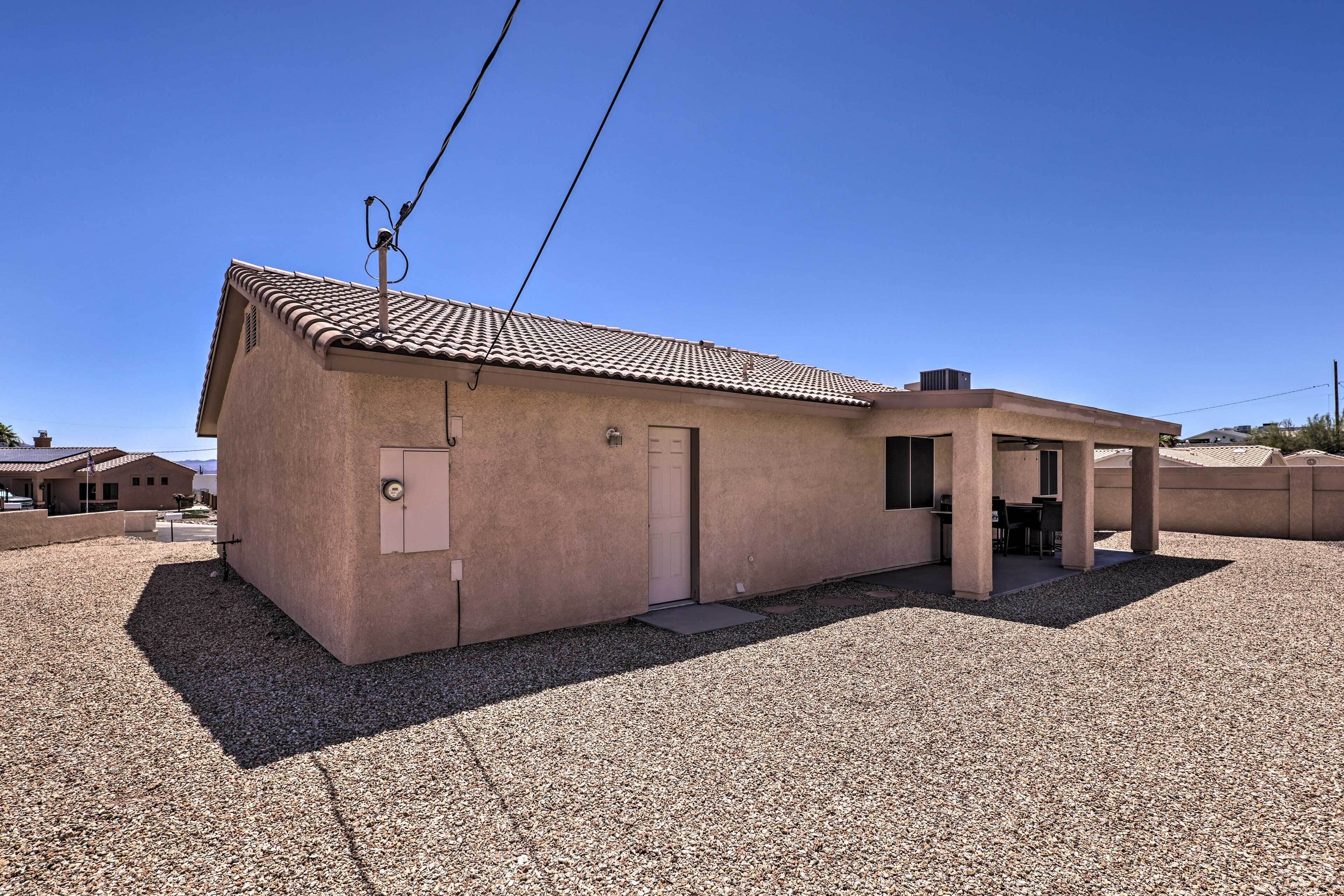 A single-story building with a tiled roof, a small porch, and a gravel driveway.