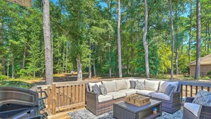 An outdoor deck with a sofa, wicker chairs, a grill, and a wooden deck railing. - Pinehurst Golf Paradise - 2 Mi to Clubhouse! (Pinehurst)