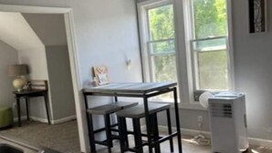 A kitchen with a dining area, a window, and a ceiling fan. - Anoka 2 bedroom apt. in Historical Victorian House (Anoka)