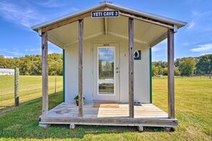 A small wooden structure labeled "Yeti Cave 3" with a door and a welcome mat.