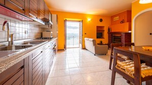 Una cucina moderna con mobili in legno, un'isola grande e un'area pranzo con tavolo e sedie.