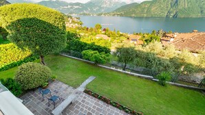 A patio with outdoor seating, a view of a lake, and a mountainous landscape in the background. - Ca Furmiga by Wonderful Italy (Tremezzina)