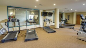 A gym with treadmills, a stationary bike, and a fan. - Waterfront Sandusky Vacation Rental: Downtown! (Sandusky)