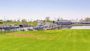A marina with boats docked, a dockside restaurant, and a grassy area in the foreground. - Waterfront Sandusky Vacation Rental: Downtown! (Sandusky)