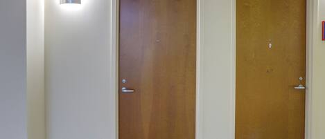 Two wooden doors with metal handles and a light fixture above the left door.