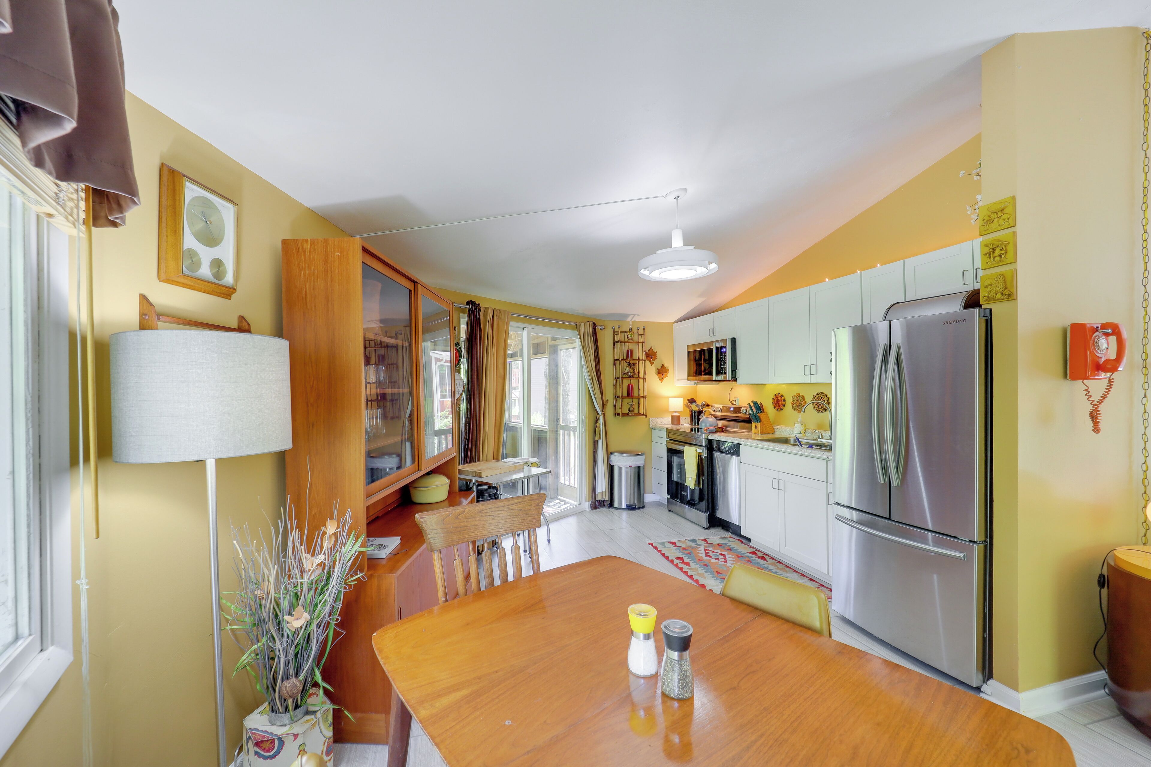 A compact kitchen with a dining area, a refrigerator, and a microwave.