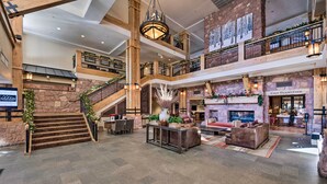 A spacious lobby with a grand staircase, a fireplace, and a café area. - Park City Condo: Steps to Canyons Village & Skiing (Park City)