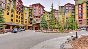 A multi-story hotel with balconies, a landscaped courtyard, and a paved driveway. - Park City Condo: Steps to Canyons Village & Skiing (Park City)