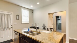 A kitchen with granite countertops, a double sink, and dark cabinetry. - Pet-friendly Davenport Home - Near Casino & Golf (Davenport)