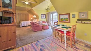 A cozy living room with a dining area, a ceiling fan, and a large window. - Riverside Tree House Suite w/ Balcony & Grill (Payson)