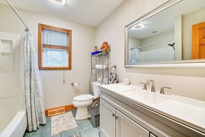 A bathroom with a toilet, sink, mirror, window, and shower curtain. - Saratoga Springs Home Near Skidmore College! (Saratoga Springs)