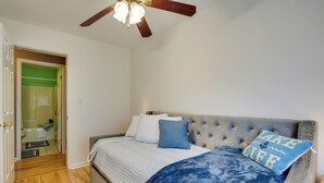 A bedroom with a bed, a ceiling fan, and a door leading to a bathroom. - Dog-friendly Freeville Home ~ 8 Mi Cayuga Lake! (Freeville)