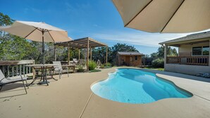 A backyard with a swimming pool, outdoor furniture, and a pergola. - New Braunfels Home w/ Pool 2 Mi to Guadalupe River (New Braunfels)