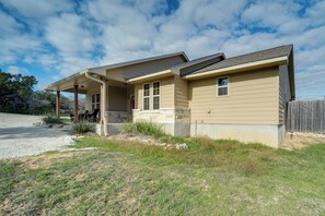 A single-story house with a covered porch, a stone foundation, and a wooden fence. - New Braunfels Home w/ Pool 2 Mi to Guadalupe River (New Braunfels)