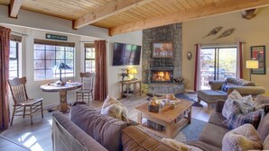 A cozy living room with a stone fireplace, comfortable seating, and a television. - Dancing Bear Lodge ~ 1 Mi to Big Bear Lake! (Big Bear Lake)