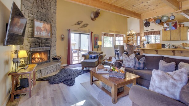 A cozy living room with a stone fireplace, wooden ceiling beams, and a comfortable seating area. - Dancing Bear Lodge ~ 1 Mi to Big Bear Lake! (Big Bear Lake)